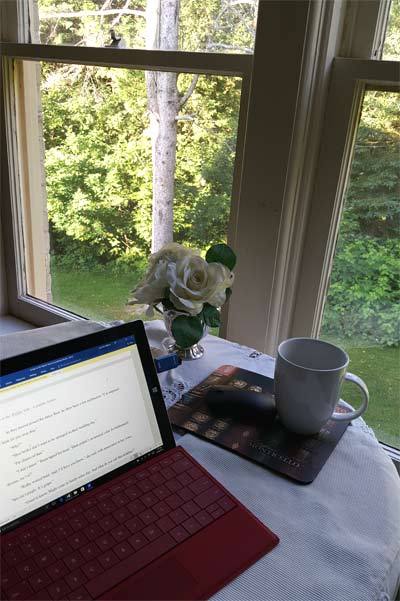 Writing on computer at table with coffee